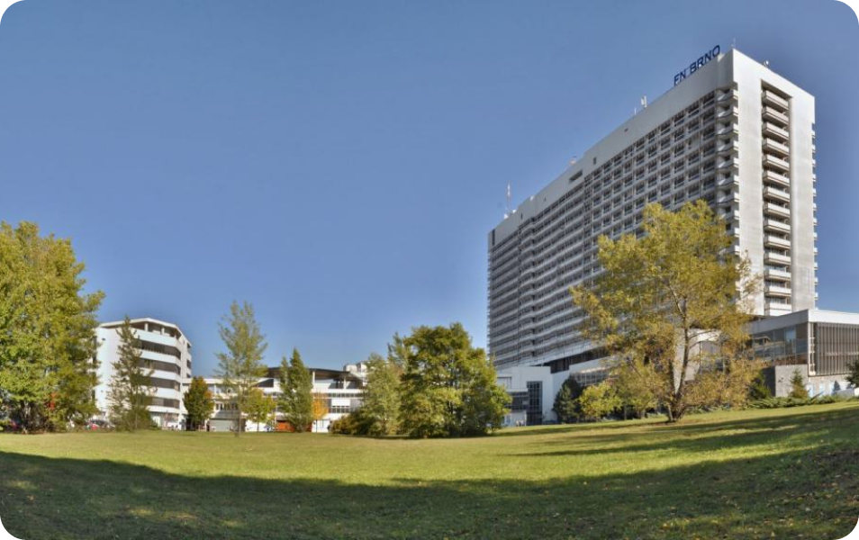 A Large Building Surrounded By Trees And Grass
